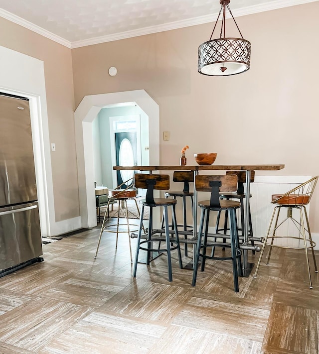 dining room with ornamental molding and light parquet floors