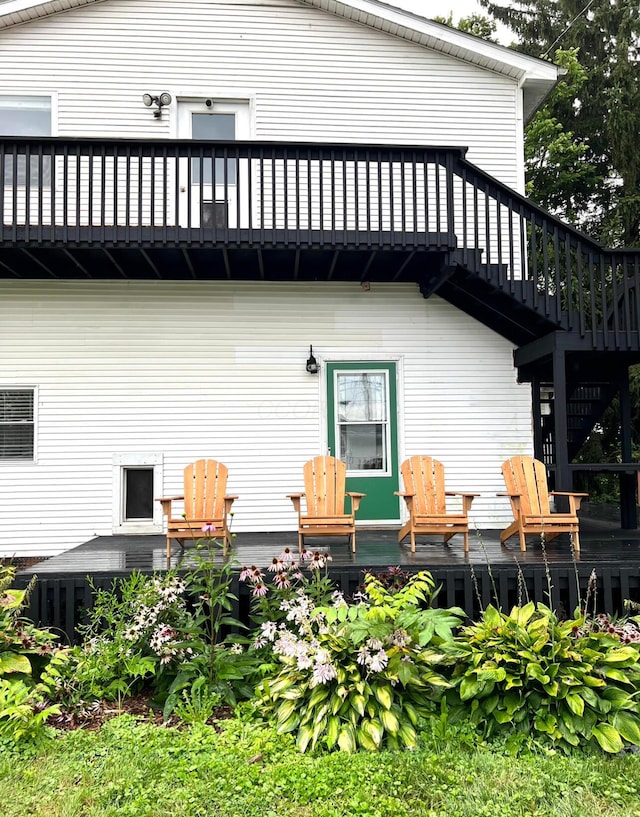 back of property with a wooden deck and a balcony