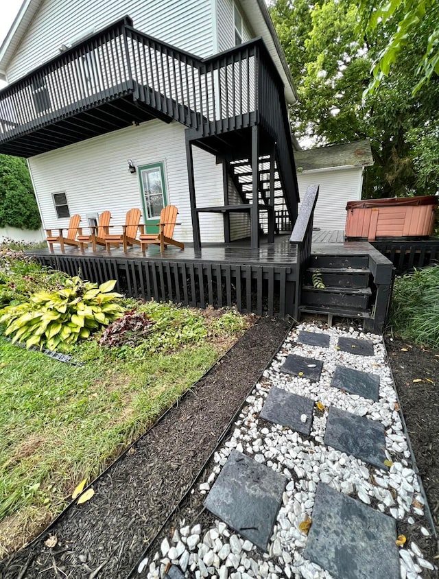 view of side of property featuring a hot tub and a deck