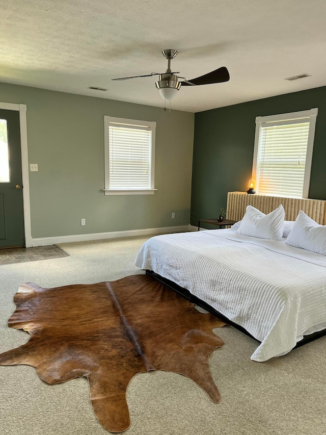 bedroom featuring ceiling fan, carpet, and multiple windows