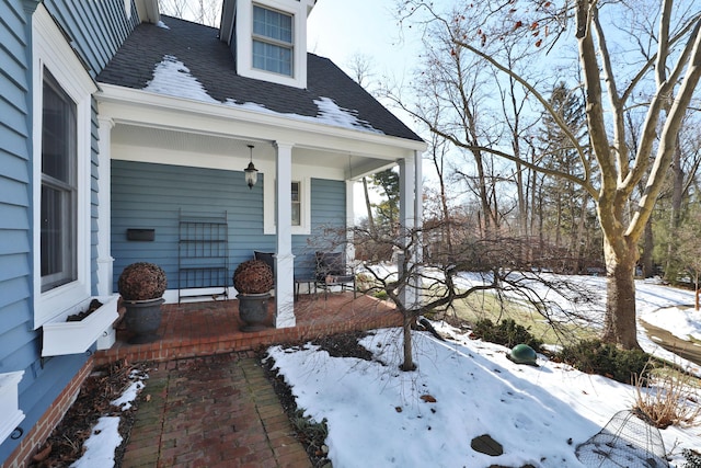 snow covered property featuring covered porch