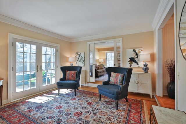 sitting room with ornamental molding, wood-type flooring, and french doors