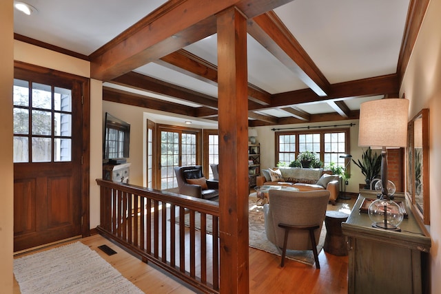 foyer entrance featuring coffered ceiling, beam ceiling, and light hardwood / wood-style flooring