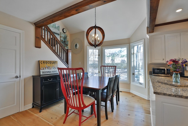 dining space with a notable chandelier, lofted ceiling with beams, and light wood-type flooring