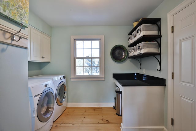 washroom featuring independent washer and dryer, cabinets, and light wood-type flooring