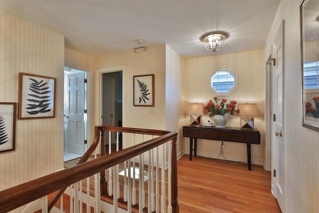 hall with a notable chandelier and light wood-type flooring