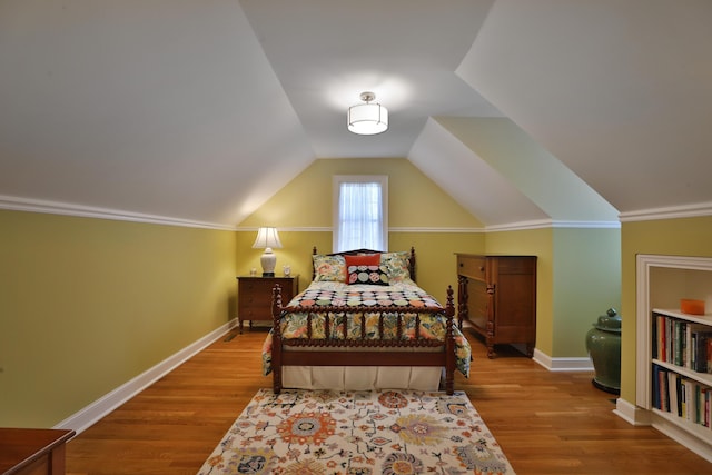 bedroom with wood-type flooring and vaulted ceiling