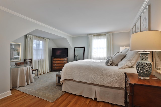 bedroom with ornamental molding and wood-type flooring