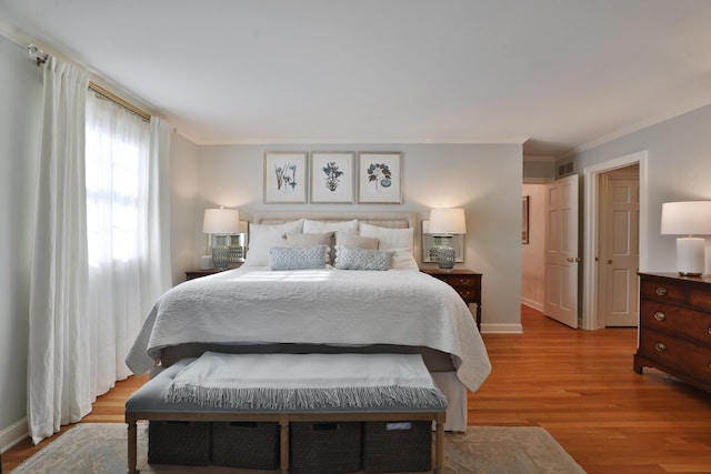 bedroom featuring crown molding and light wood-type flooring