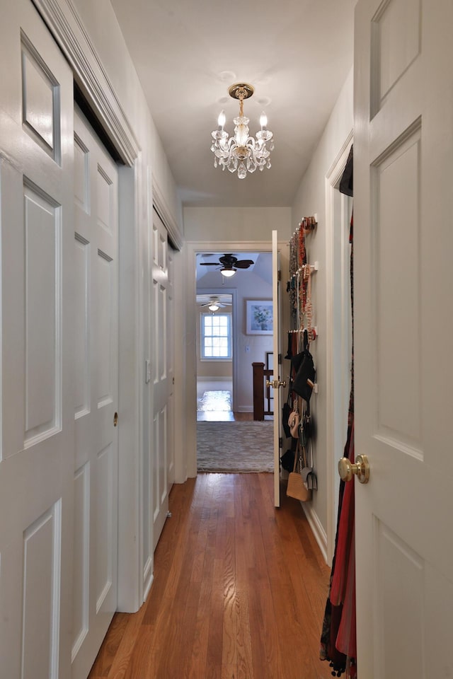 hall featuring hardwood / wood-style flooring and a notable chandelier