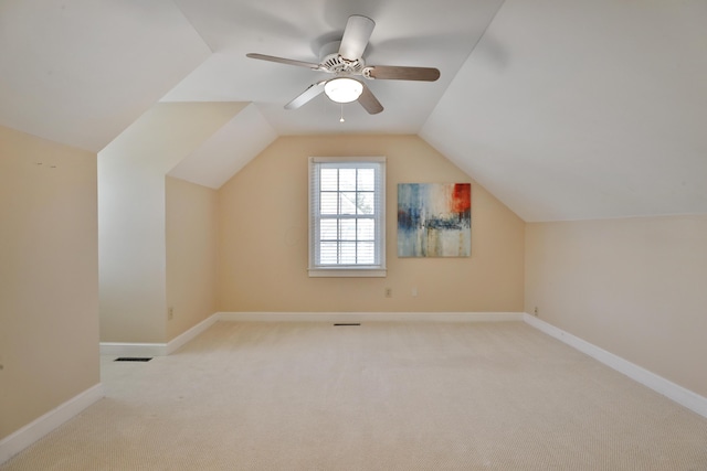 additional living space with ceiling fan, light colored carpet, and lofted ceiling