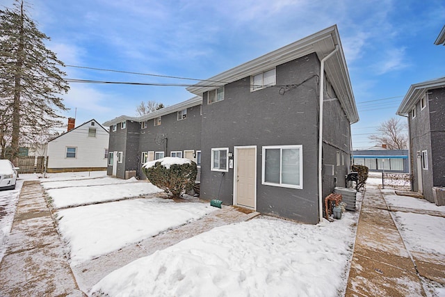 snow covered property featuring central AC unit