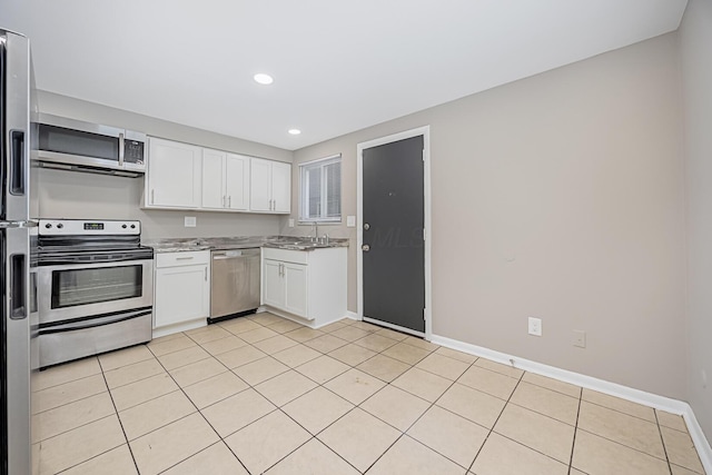 kitchen featuring stainless steel appliances, white cabinetry, sink, and light tile patterned floors