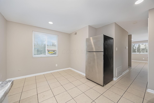 kitchen featuring light tile patterned floors and stainless steel refrigerator