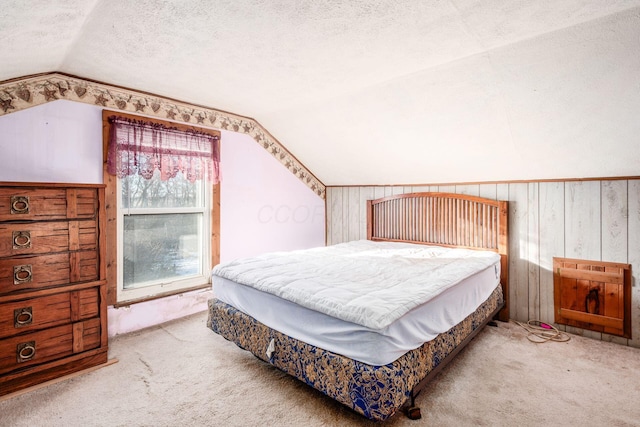 carpeted bedroom featuring vaulted ceiling, a textured ceiling, and wood walls