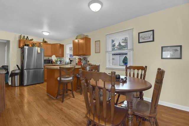 dining space featuring sink, light hardwood / wood-style flooring, and a wealth of natural light