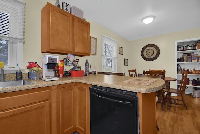 kitchen featuring wood-type flooring, dishwasher, kitchen peninsula, and a wealth of natural light