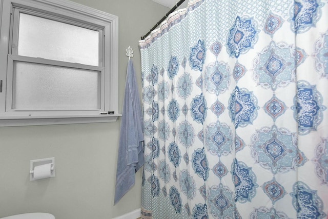 bathroom featuring walk in shower and toilet