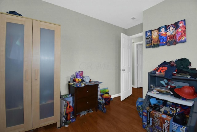 bedroom featuring dark wood-type flooring and a closet