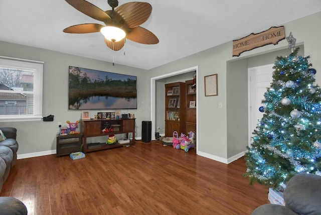 living room featuring dark wood-type flooring and ceiling fan