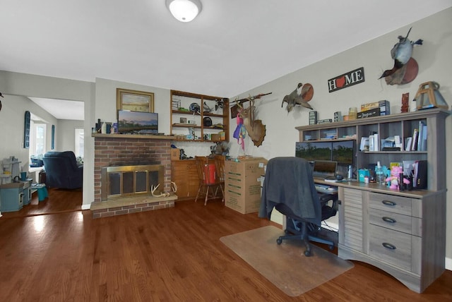 office with wood-type flooring and a brick fireplace