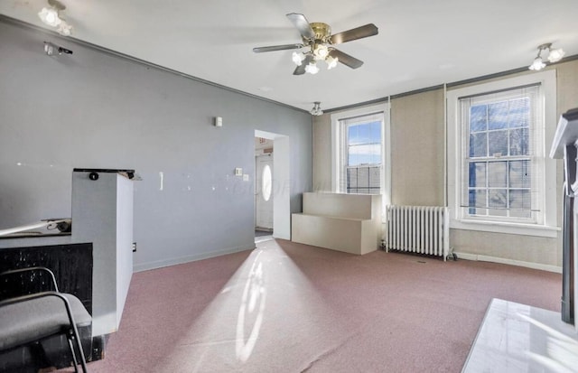 interior space with radiator heating unit, ceiling fan, and carpet