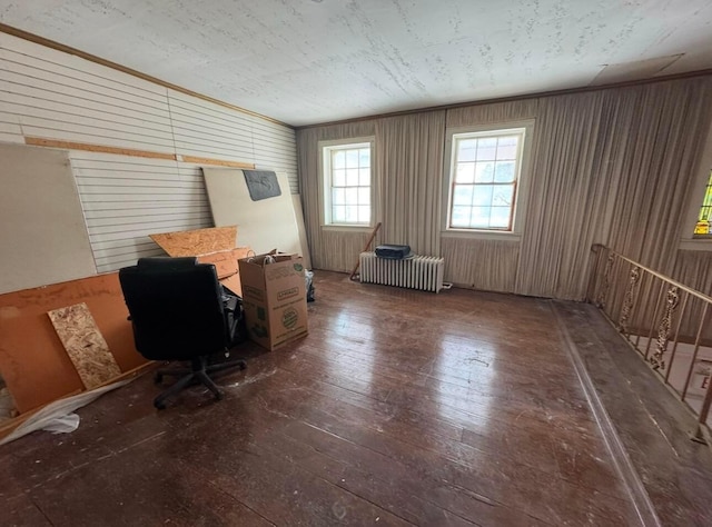 unfurnished office featuring ornamental molding, radiator heating unit, dark hardwood / wood-style flooring, and wood walls