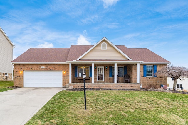 view of front of house featuring covered porch, a front yard, and a garage