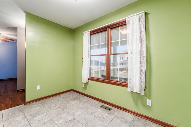 empty room featuring ceiling fan and light tile patterned flooring