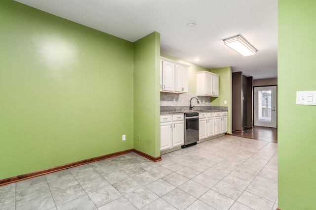 kitchen featuring sink, light tile patterned floors, backsplash, light stone countertops, and white cabinets