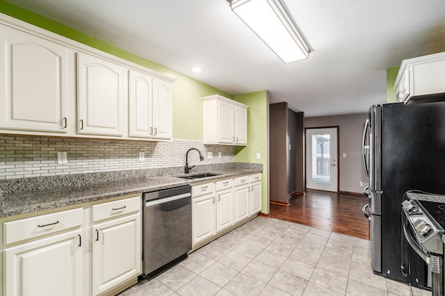 kitchen with sink, appliances with stainless steel finishes, white cabinets, decorative backsplash, and dark stone counters