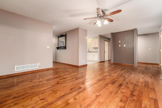 unfurnished living room featuring ceiling fan and light hardwood / wood-style floors