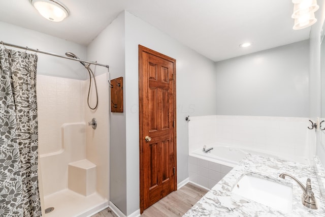 bathroom featuring wood-type flooring, independent shower and bath, and vanity