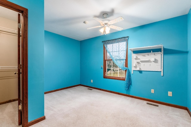 unfurnished room with light colored carpet and ceiling fan