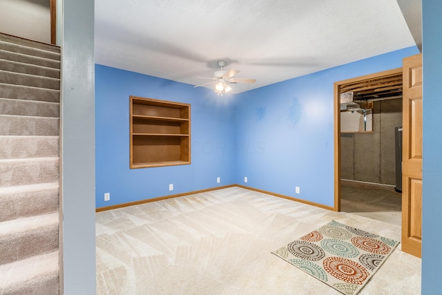 interior space featuring light carpet, built in features, and ceiling fan