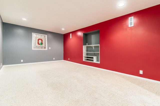 carpeted spare room featuring built in features