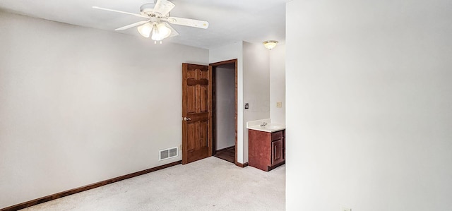 spare room featuring light carpet, sink, and ceiling fan