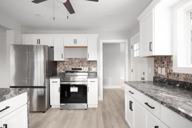 kitchen featuring dark stone countertops, stainless steel appliances, light hardwood / wood-style floors, and white cabinets