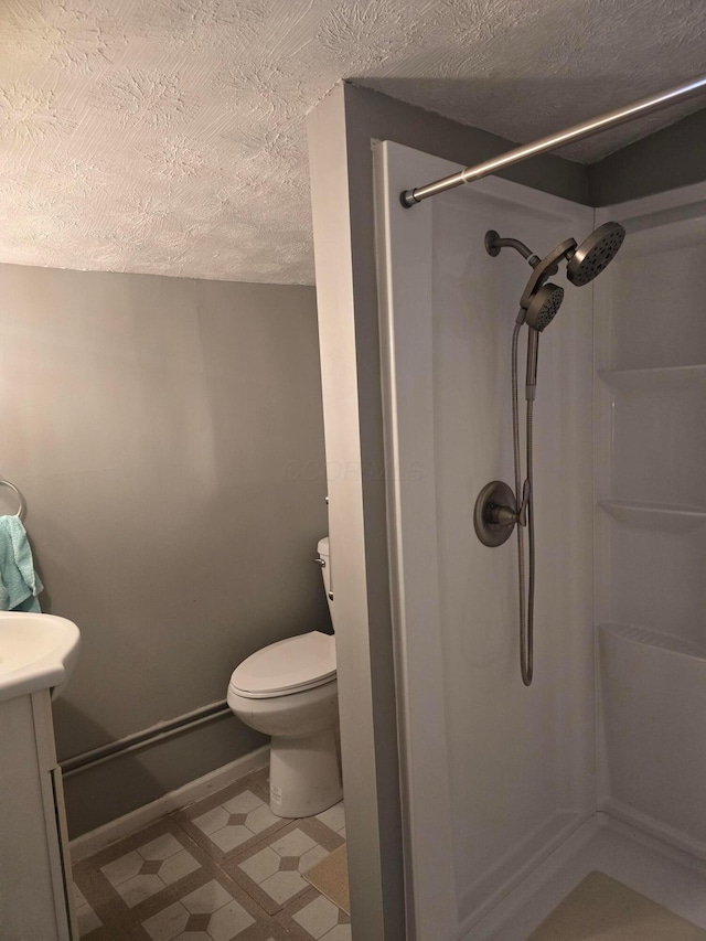 bathroom with vanity, a textured ceiling, toilet, and walk in shower