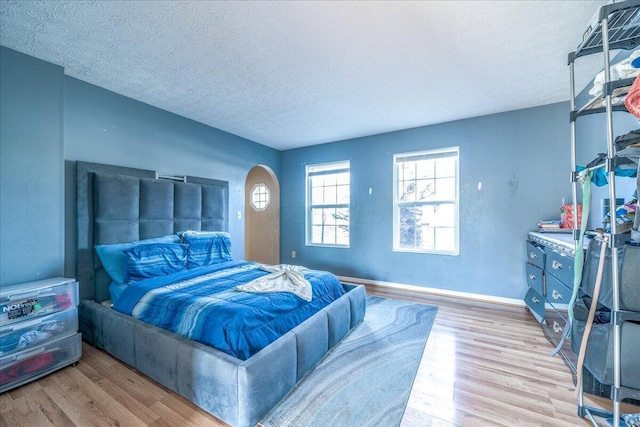 bedroom with light hardwood / wood-style floors and a textured ceiling