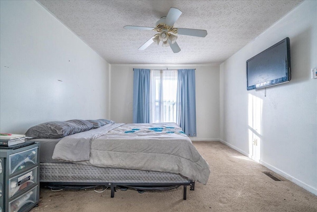 carpeted bedroom with a textured ceiling and ceiling fan