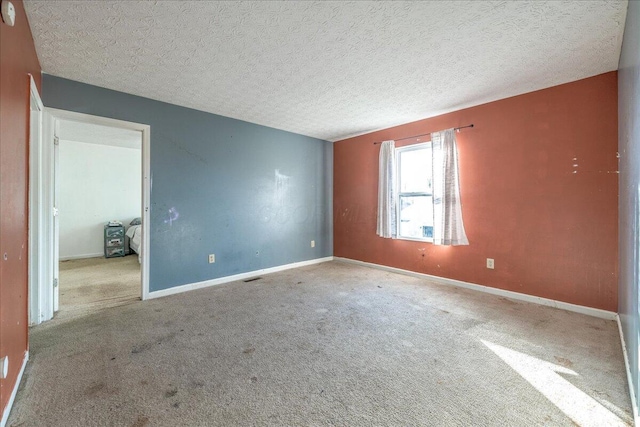 spare room with light colored carpet and a textured ceiling