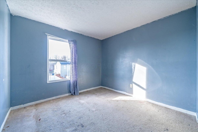 unfurnished room with light carpet and a textured ceiling