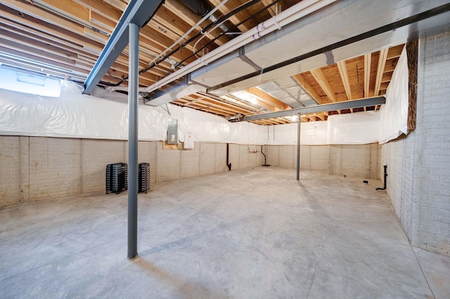 basement with electric panel and brick wall