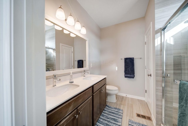 bathroom with vanity, toilet, and a shower with shower door