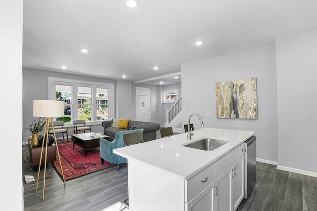 kitchen with sink, dark wood-type flooring, dishwasher, a kitchen island with sink, and white cabinetry