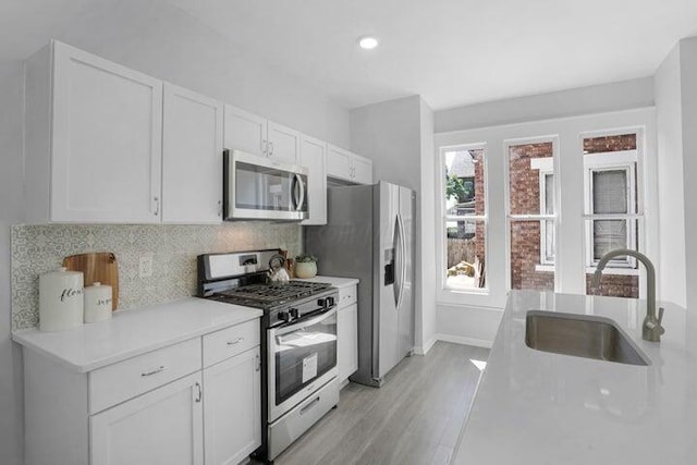 kitchen featuring white cabinetry, stainless steel appliances, sink, and tasteful backsplash