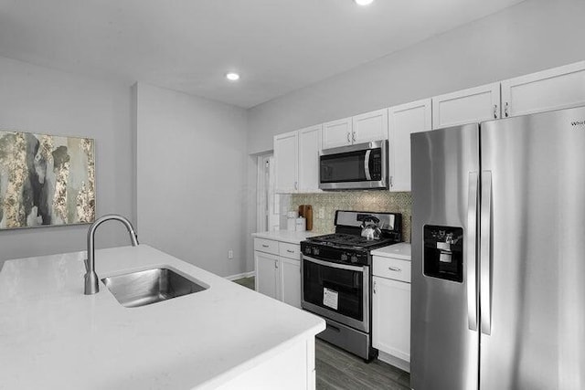 kitchen featuring sink, appliances with stainless steel finishes, dark hardwood / wood-style floors, white cabinets, and backsplash