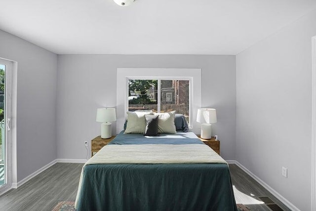 bedroom featuring multiple windows and dark wood-type flooring