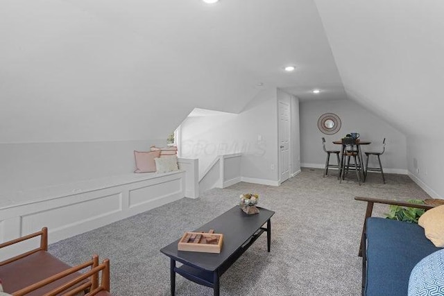 living room featuring carpet floors and vaulted ceiling